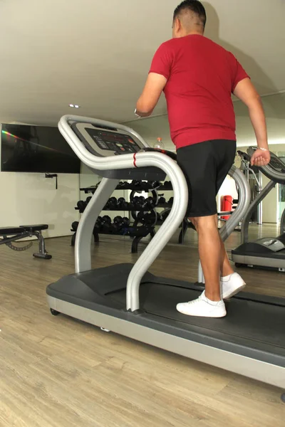 stock image Forty-year-old dark-haired Latino adult man exercises his legs on the treadmill as a treatment for diseases such as tendonitis, tendon rupture or cruciate ligament injury