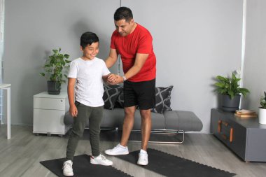 Öğrenci bir öğretmen olarak evindeki boks sınıfında baba ve oğul arasında spor teknikleri ve alıştırmaları öğretiyorum.