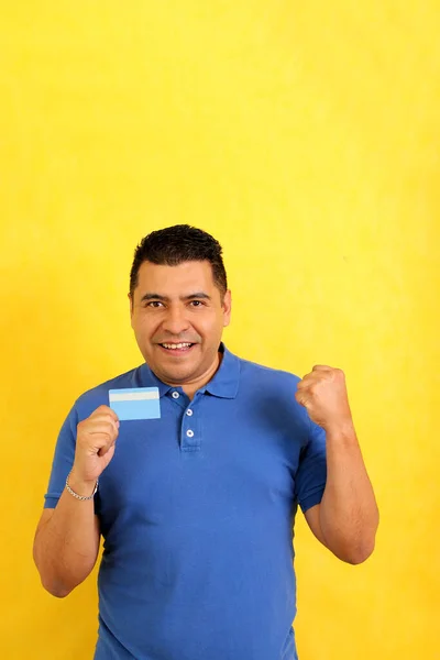 40歳の浅黒い肌のラテン系の大人の男は 彼のクレジットカードを示しています ストックフォト
