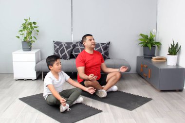 Latin baba ve oğul yoga yapıyor, dinginlik ve rahatlama için geleneksel ruhsal, fiziksel ve zihinsel bir disiplin, onların güçlü ve zayıf yönlerini takdir etmeyi öğreniyorlar.