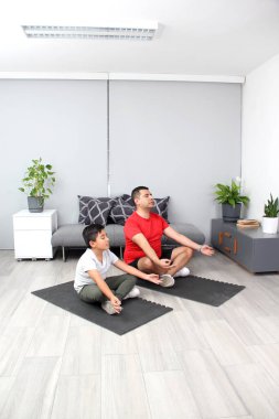 Latin baba ve oğul yoga yapıyor, dinginlik ve rahatlama için geleneksel ruhsal, fiziksel ve zihinsel bir disiplin, onların güçlü ve zayıf yönlerini takdir etmeyi öğreniyorlar.