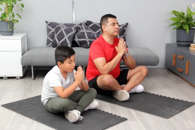 Latin baba ve oğul yoga yapıyor, dinginlik ve rahatlama için geleneksel ruhsal, fiziksel ve zihinsel bir disiplin, onların güçlü ve zayıf yönlerini takdir etmeyi öğreniyorlar.