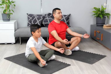 Latin baba ve oğul yoga yapıyor, dinginlik ve rahatlama için geleneksel ruhsal, fiziksel ve zihinsel bir disiplin, onların güçlü ve zayıf yönlerini takdir etmeyi öğreniyorlar.