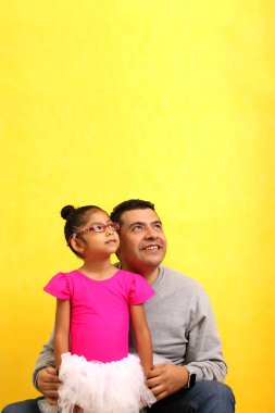 Boşanmış, kahverengi bir baba, balerin gibi giyinmiş Latin kızını bacaklarında taşıyor. Oynuyorlar ve sevgilerini gösteriyorlar.