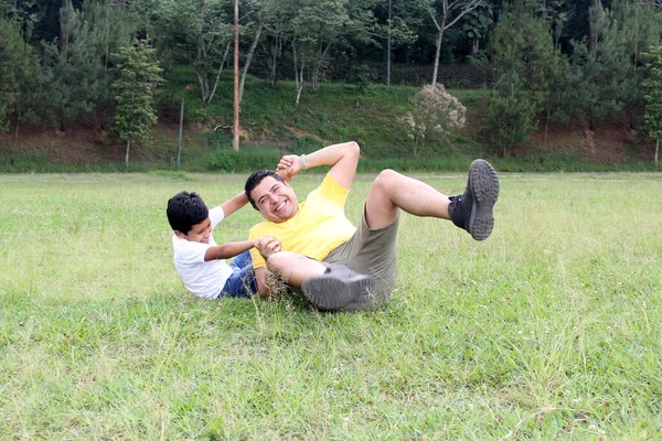 9岁的单身爸爸和深色头发的儿子离婚后 在公园里玩耍 在没有高科技的贫穷环境中共度美好时光 — 图库照片