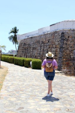 Yetişkin Latin kadın güneş gözlüğü ve sombrero takıyor Acapulco, Guerrero, Meksika 'nın tarihi caddelerinde turist olarak yürüyor.