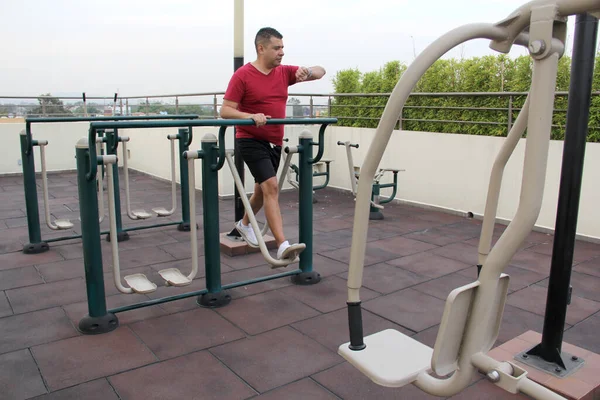 stock image Dark-haired 40-year-old Latino man exercises on the roof garden of his building with effort and commitment to lose weight and improve his health