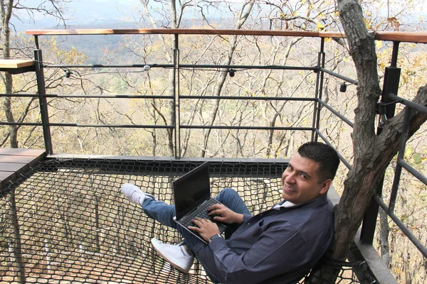 Letý Latinoameričan Pracuje Svým Laptopem Dřevěné Kabině Uprostřed Lesa Jako — Stock fotografie
