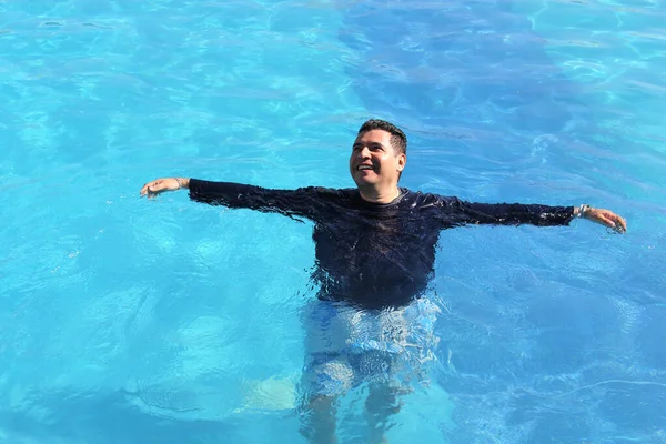 40多岁的拉美人喜欢在暑假里穿泳衣和衬衫在游泳池里放松一下 以免晒伤 — 图库照片