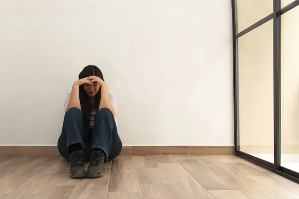 40岁的拉蒂娜女人坐在空房子的地板上 看起来既伤心又沮丧 — 图库照片