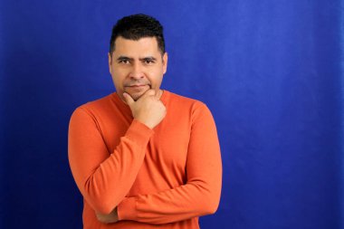 Happy and successful 40-year-old dark-haired Latino man smiles and poses for the camera relaxed and calm