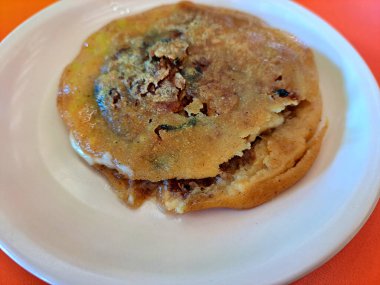 Meksika yemeği Gordita de Chicharron ortasını dolduran çok kalın bir tortilla. Sıcak sos, krema ve peynirle hazırlanmış.