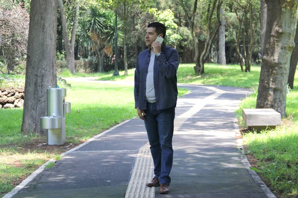 Parktaki Yaşındaki Koyu Renk Saçlı Latin Adam Cep Telefonunu Uzaktan — Stok fotoğraf