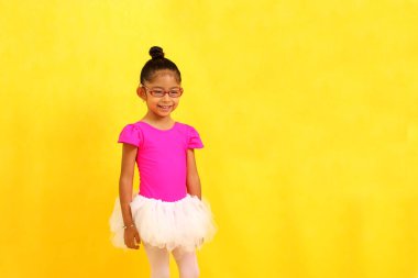 4 yaşında esmer, Latin bir kız. Yaz sınıfında bale yapıyor. Mayolu, etekli, heyecanlı ve mutlu.