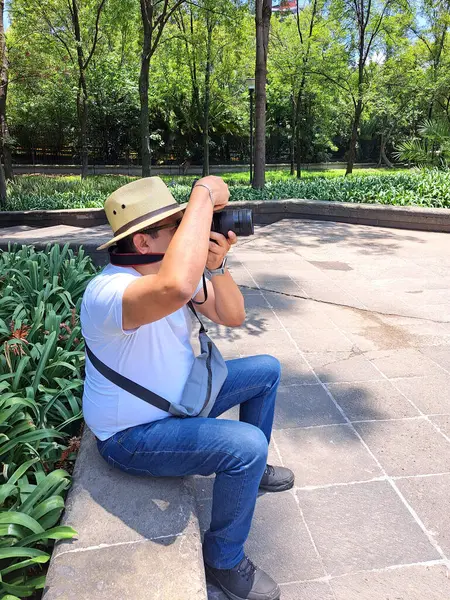 Siyah saçlı Latin yetişkin adam profesyonel kameralı açık hava fotoğrafçısı. Gülümse.!