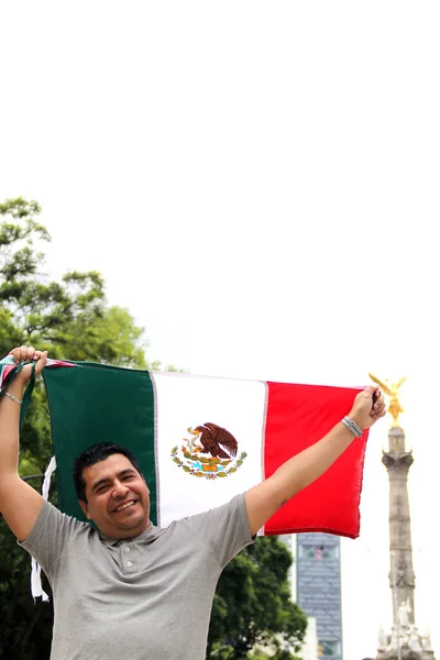 暗髪の大人のメキシコ人は誇らしげにメキシコシティのトリコロール旗を掲げ 彼の国 伝統に対する彼の愛を祝います — ストック写真