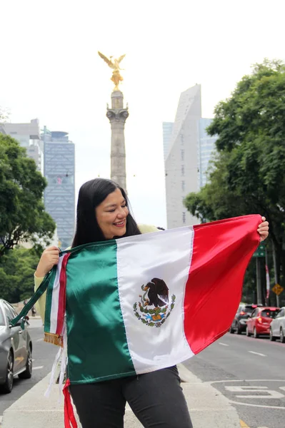 Stock image Latin adult woman shows the flag of mexico proud of the culture and tradition of her country, celebrates mexican patriotism