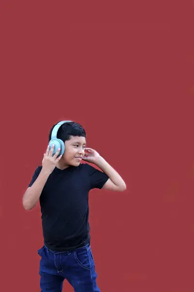 9歳の暗い肌のラティーノの少年がヘッドフォンに耳を傾け 興奮して幸せに踊りながら音楽を楽しんでいる — ストック写真