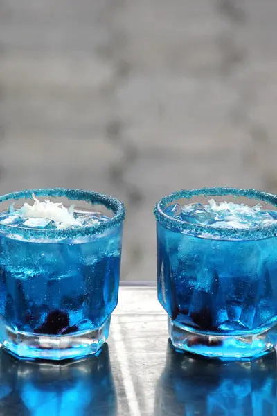 Popular alcoholic drink in Mexico called Azulitos or Pitufos prepared with vodka, a blue energy drink, garnished with chamoy and chili