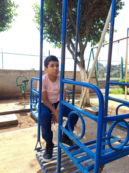 stock image 9-year-old dark-skinned Latin boy is sad in the games, suffers from his father's abandonment and living in poverty