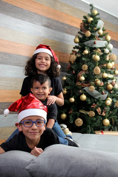 Drei Kleine Dunkelhäutige Latino Brüder Warten Auf Den Weihnachtsmann Und Stockbild