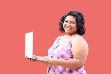 20 yaşındaki şişman Latin esmer kadın laptopunu ödevlerini yapmak, iş aramak, yoksulluk içinde alışveriş yapmak için kullanıyor.