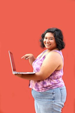 20 yaşındaki şişman Latin esmer kadın laptopunu ödevlerini yapmak, iş aramak, yoksulluk içinde alışveriş yapmak için kullanıyor.