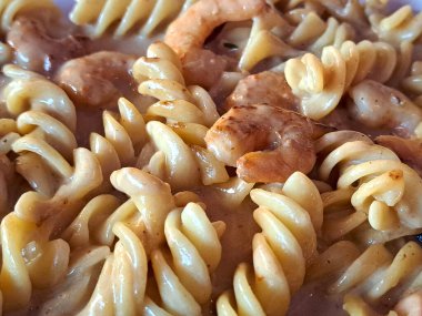 Kremalı soslu lezzetli fusilli makarna. Karides ve ahtapot gibi deniz ürünleri.