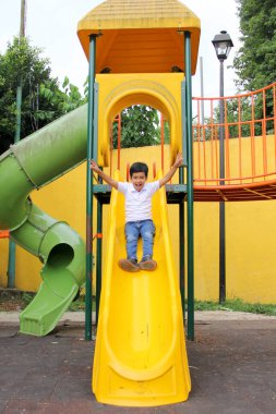 9 yaşındaki esmer tenli Latin çocuk, hiperaktivite terapisi olarak yoksulluk içinde yaşayan fiziksel bir aktivite olarak oyun bahçesinde oynuyor.