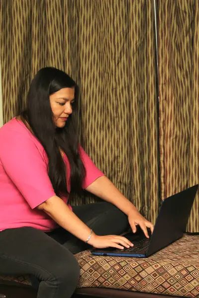 40-year-old Latina woman uses her laptop computer to work, make video calls, send messages, make appointments, buy and pay online
