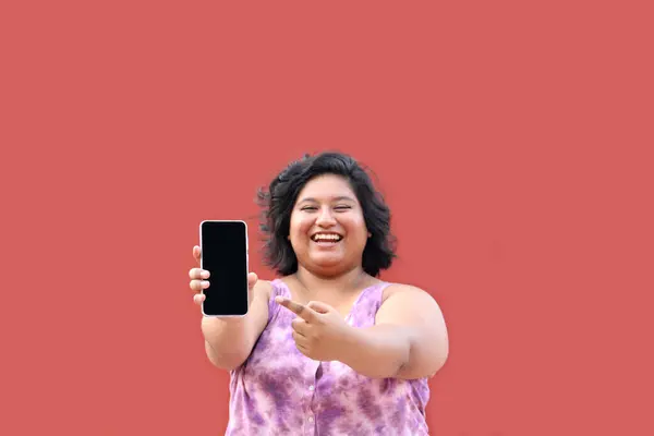 stock image Young overweight brunette Latin woman of 20 years old shows the screen of her cell phone very happy about promotions and discounts