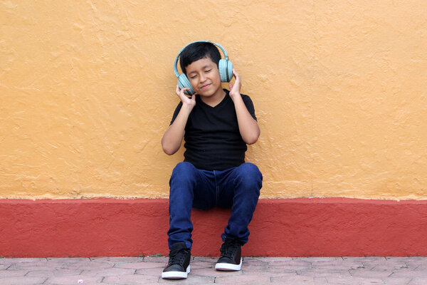 9-летний темнокожий латиноамериканец использует слуховые аппараты, которые изменяют способность к обучению, памяти и удержанию, вызывая социальную изоляцию, гипокаузию и звон в ушах