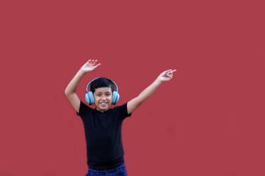 9 yaşındaki koyu tenli Latin çocuk kulaklıklarıyla müzik dinliyor ve heyecanla indirimlere ve promosyonlara işaret ediyor.