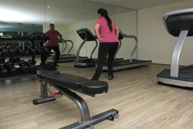40 yaşındaki Latin kadın diyabet ve hipertansiyondan kaçınmak için spor salonunda egzersiz yapıyor.