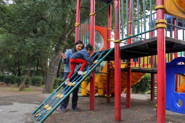 Boşanmış bekar anne ve esmer Latin 4 yaşındaki kız çocuk yoksulluk ve yalnızlık içinde parkta oyun oynuyor dinlenirken kaliteli zaman geçiriyorlar.