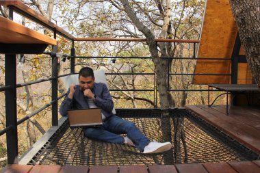 40 yaşındaki esmer tenli Latin adam bilgisayarını ve cep telefonunu dijital göçebe olarak kullanıyor. Ödemeler, alışverişler ve tarihler yapıyor.