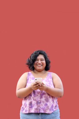 20 yaşındaki Latin esmer kadın cep telefonunu mesaj göndermek, arama yapmak, satın almak, çalışmak ve randevu almak için kullanıyor.