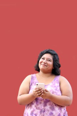 20 yaşındaki Latin esmer kadın cep telefonunu mesaj göndermek, arama yapmak, satın almak, çalışmak ve randevu almak için kullanıyor.