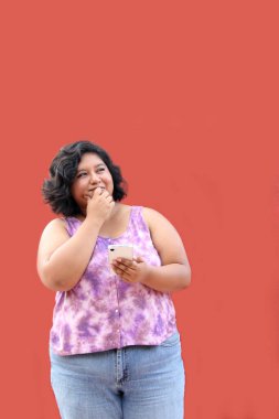 20 yaşındaki Latin esmer kadın cep telefonunu mesaj göndermek, arama yapmak, satın almak, çalışmak ve randevu almak için kullanıyor.