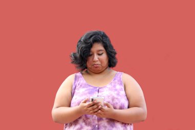 20 yaşındaki Latin esmer kadın cep telefonunu mesaj göndermek, arama yapmak, satın almak, çalışmak ve randevu almak için kullanıyor.