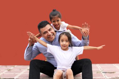 Divorced single dad spends time with his two young brunette Latina daughters celebrating Father's Day in poverty