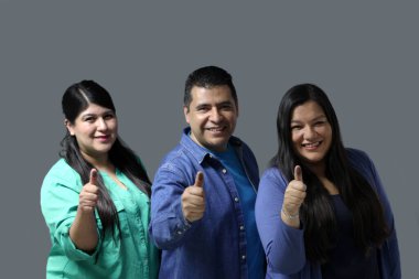 Two Latino women and a man show their thumb inked with indelible electoral ink after voting in the election