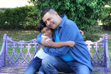 Boşanmış bekar bir baba, 10 yaşındaki esmer tenli Latin oğluyla bankta oturup Babalar Günü 'nü kutluyor.