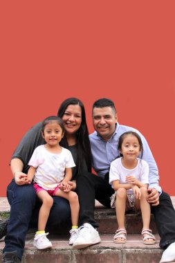 Baba, anne ve iki koyu tenli Latin kızı birlikte eğlenip eğleniyorlar.