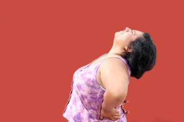 20 yaşındaki genç esmer kadın gerilim ve kötü duruş nedeniyle sırt, omurga ve boyun ağrısından muzdarip.