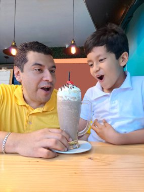 Boşanmış bekar bir baba ve 9 yaşındaki oğlu kahve dükkanında milkshake içip babalar gününü mutlu kutluyorlar.