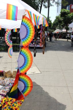 Mexico City, Mexico - 12 Haziran 2024: Gurur ayında yürüyüş için gey gökkuşağı bayraklı ürünler satan sokak tezgahı