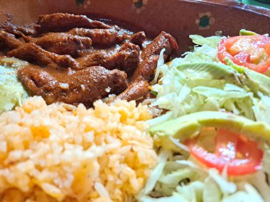 Kırmızı soslu kurbağa bacağından yapılmış yemek, pilav ve salata. Mutfak spesiyali olarak kabul edilir.