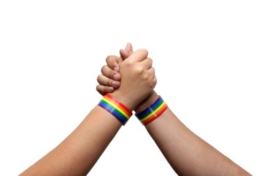 Eşcinsel bayrağının gökkuşağı renginde bilezikleri olan ve LGBTQIA + topluluğunu temsil eden iki kişinin iki eli, toplulukları için gururla gösteriliyor.