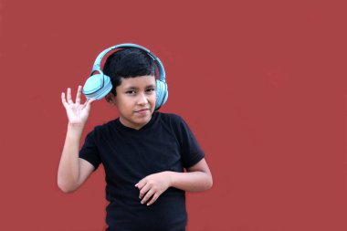 9 yaşındaki esmer tenli Latin çocuk, otizm ve dikkat eksikliği hiperaktivite bozukluğu nedeniyle gürültü yalıtımlı kulaklık kullanıyor.